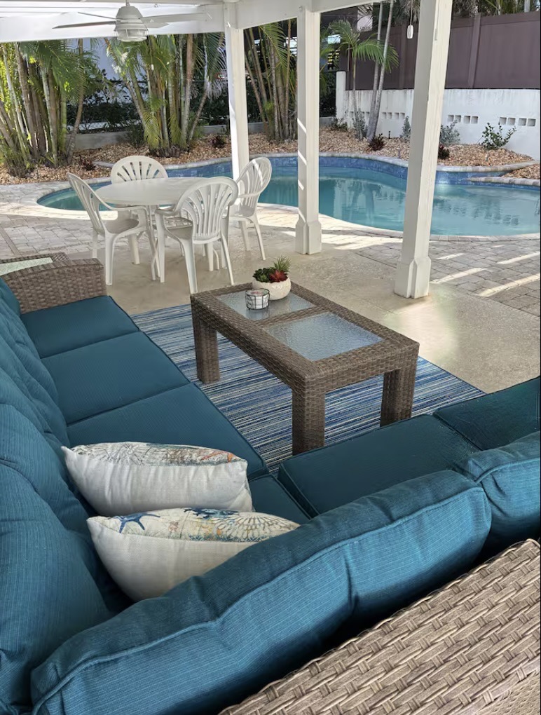 The covered patio with ceiling fans overlooks the heated pool.